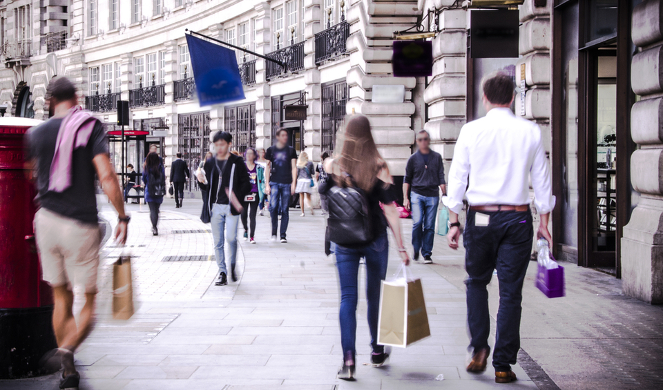 People walking down a busy shopping street in London, illustrating a blog post on changing financial plans