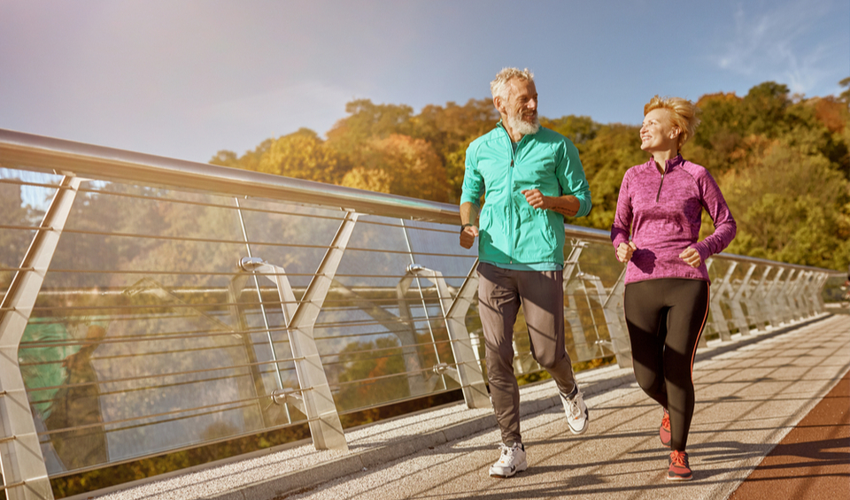 A mature couple jogging across a bridge illustrating an article on Lasting Power of Attorny