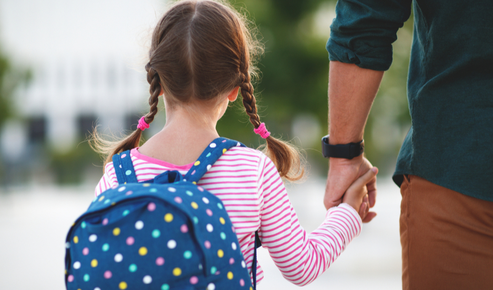 A father holding his daughter’s hand as they walk, illustrating an article about being a trustee