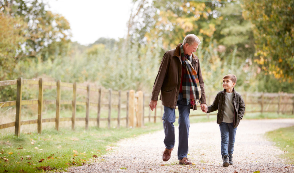 grandfather walking with grandson in the countryside, illustrating an article on things to include in your will