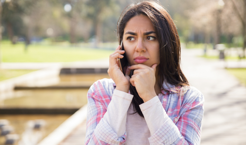 Lady looking concerned about a phone call illustrating an article about the red flags to help you identify a scam